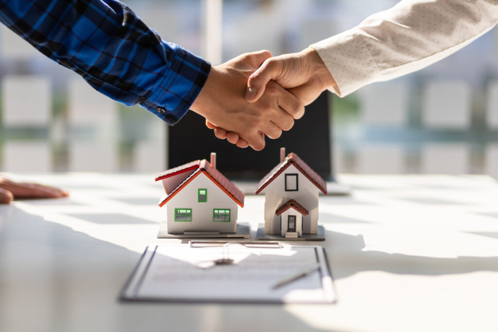 Homeowners insurance agents shake hands after the signing of the contract agreement is complete.